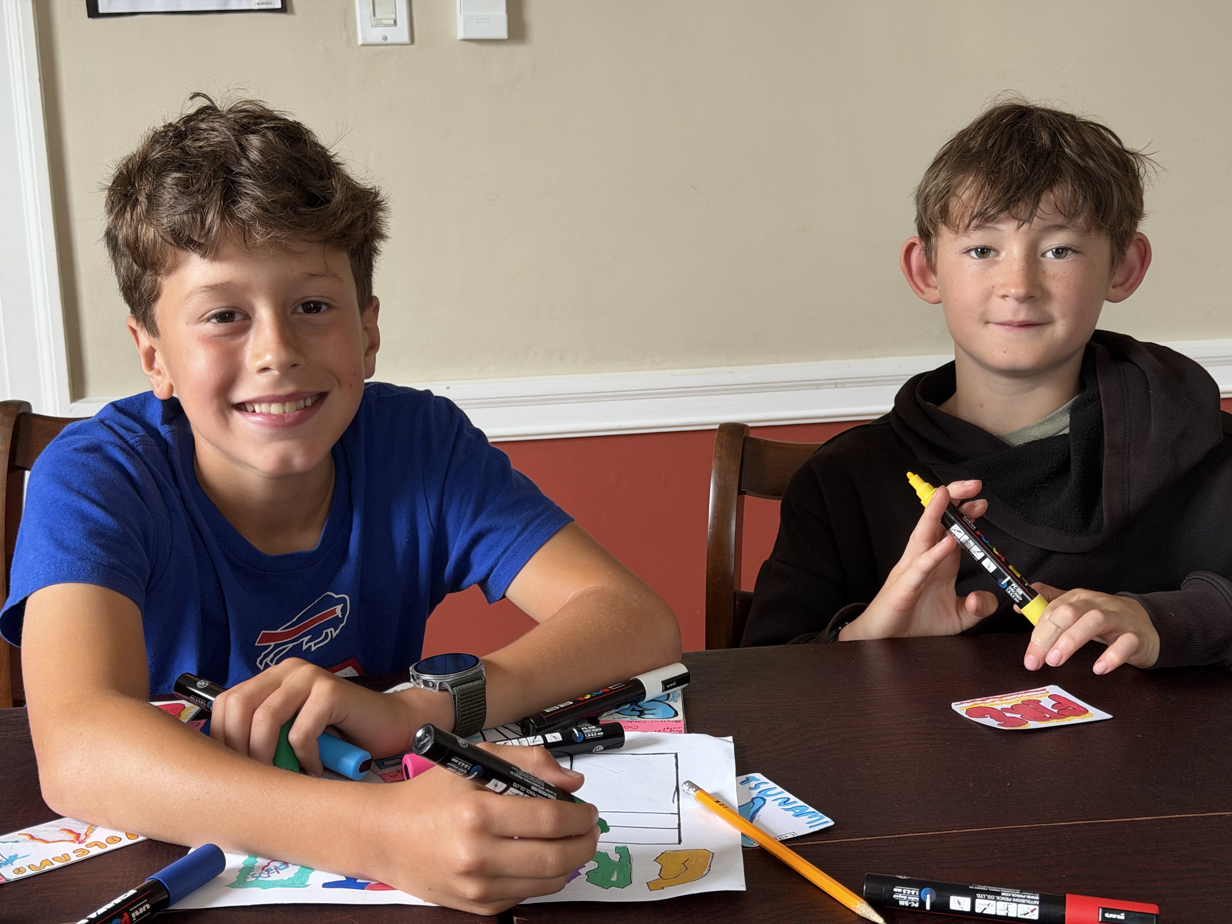 Jackson and Jack drawing graffiti cards together with paint markers